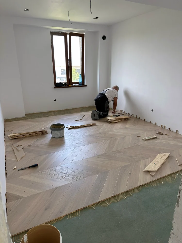 Parchet stratificat în model spic, în timpul montajului
