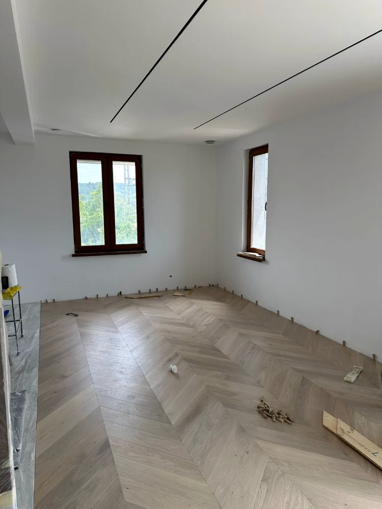 Cameră cu parchet stratificat montat în model spic, înainte de montarea plintelor