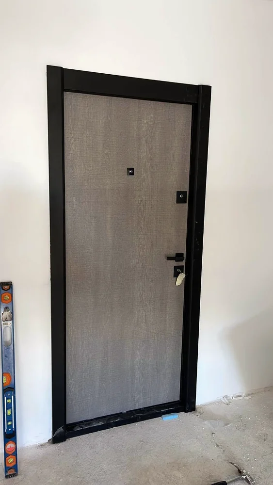 Ușă de acces apartament cu decor cu aspect de piatră și toc negru