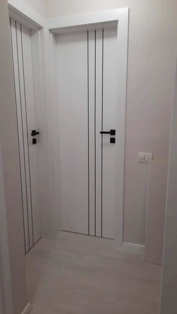 Uși de interior albe cu linii verticale negre și mânere negre