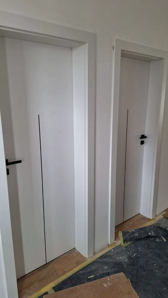 Uși de interior albe, minimaliste, cu mânere negre