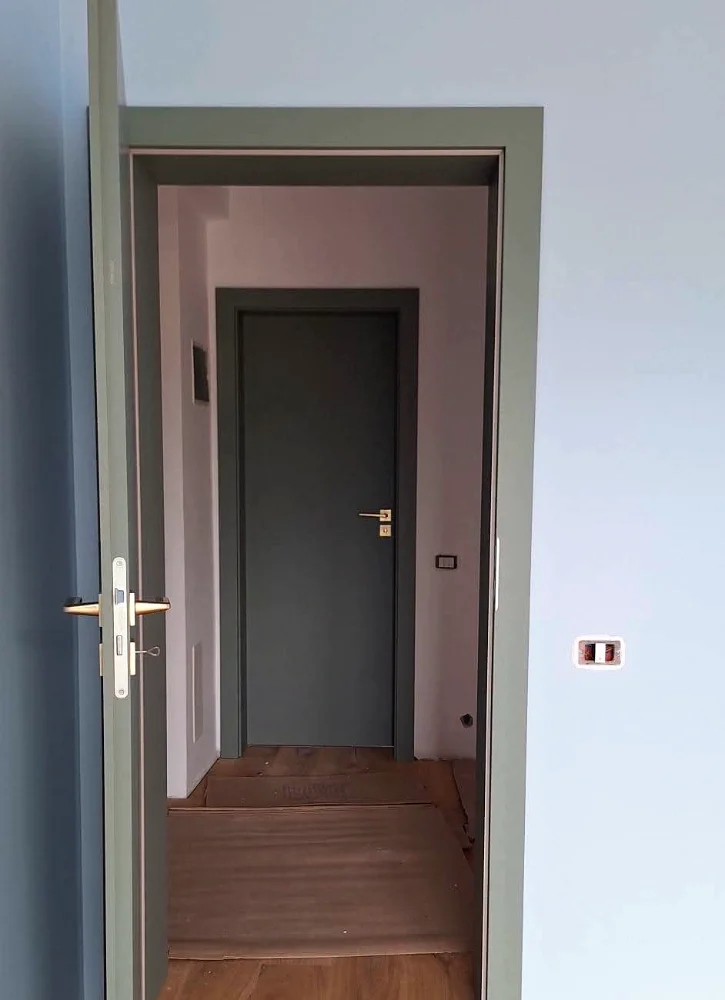 Uși de interior gri pe un hol, una cu fantă verticală de sticlă neagră