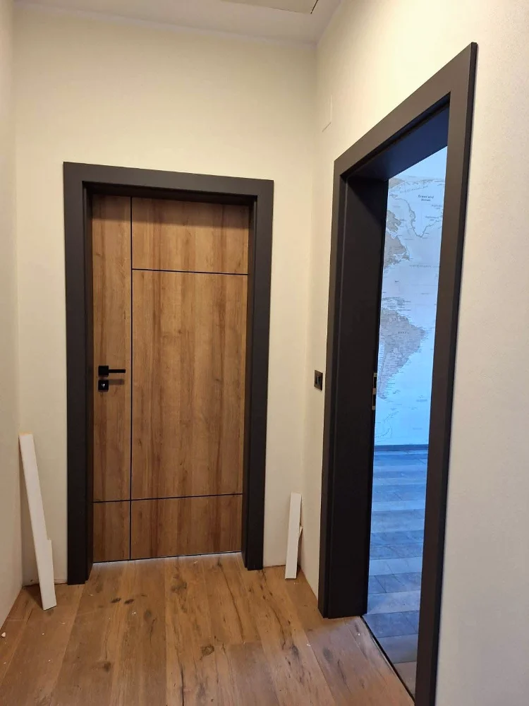 Ușă de interior în decor stejar cu linii orizontale negre și toc închis la culoare